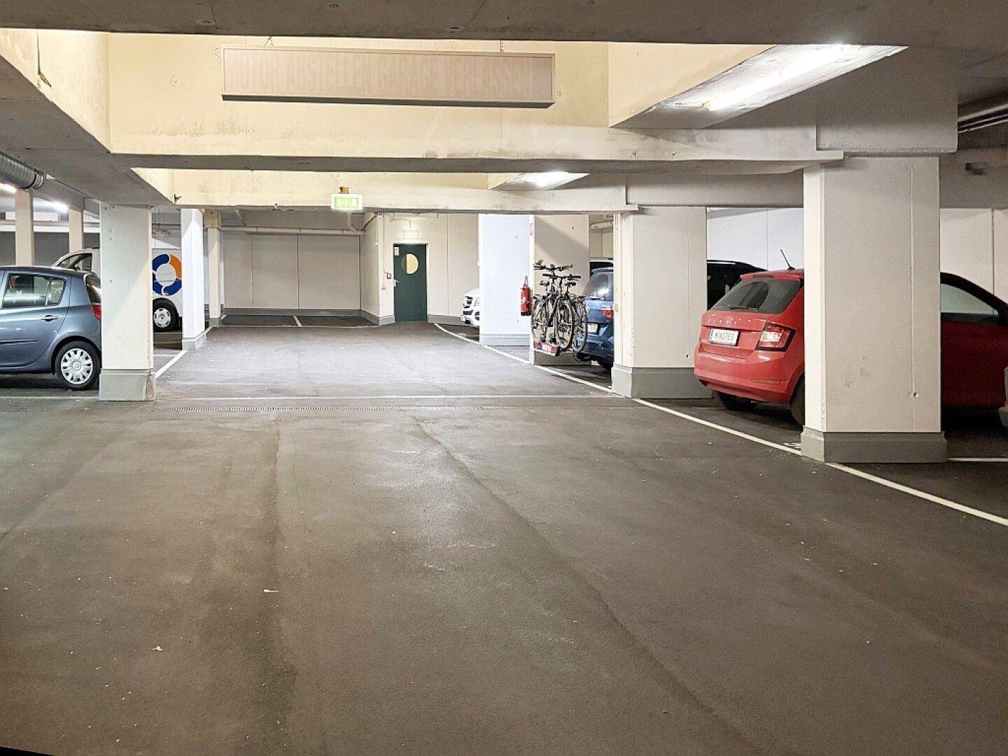 Geräumige Tiefgarage mit mehreren Stellplätzen und Fahrrädern.
