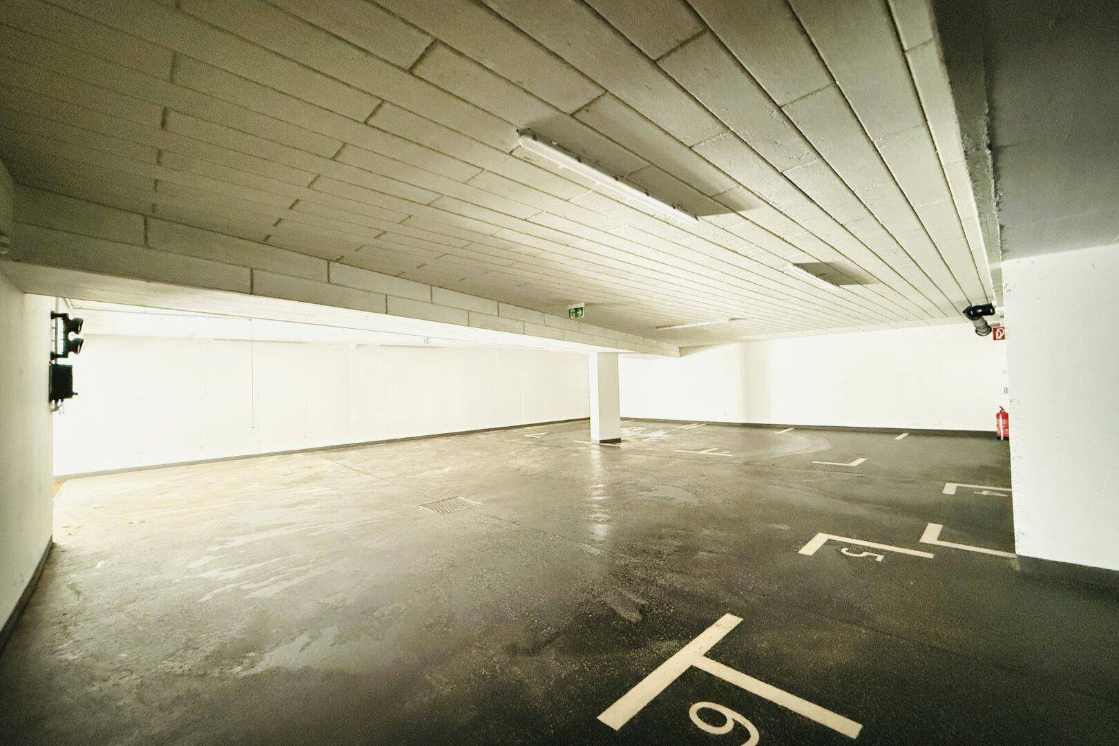 Geräumige Tiefgarage mit markierten Stellplätzen und guter Beleuchtung.
