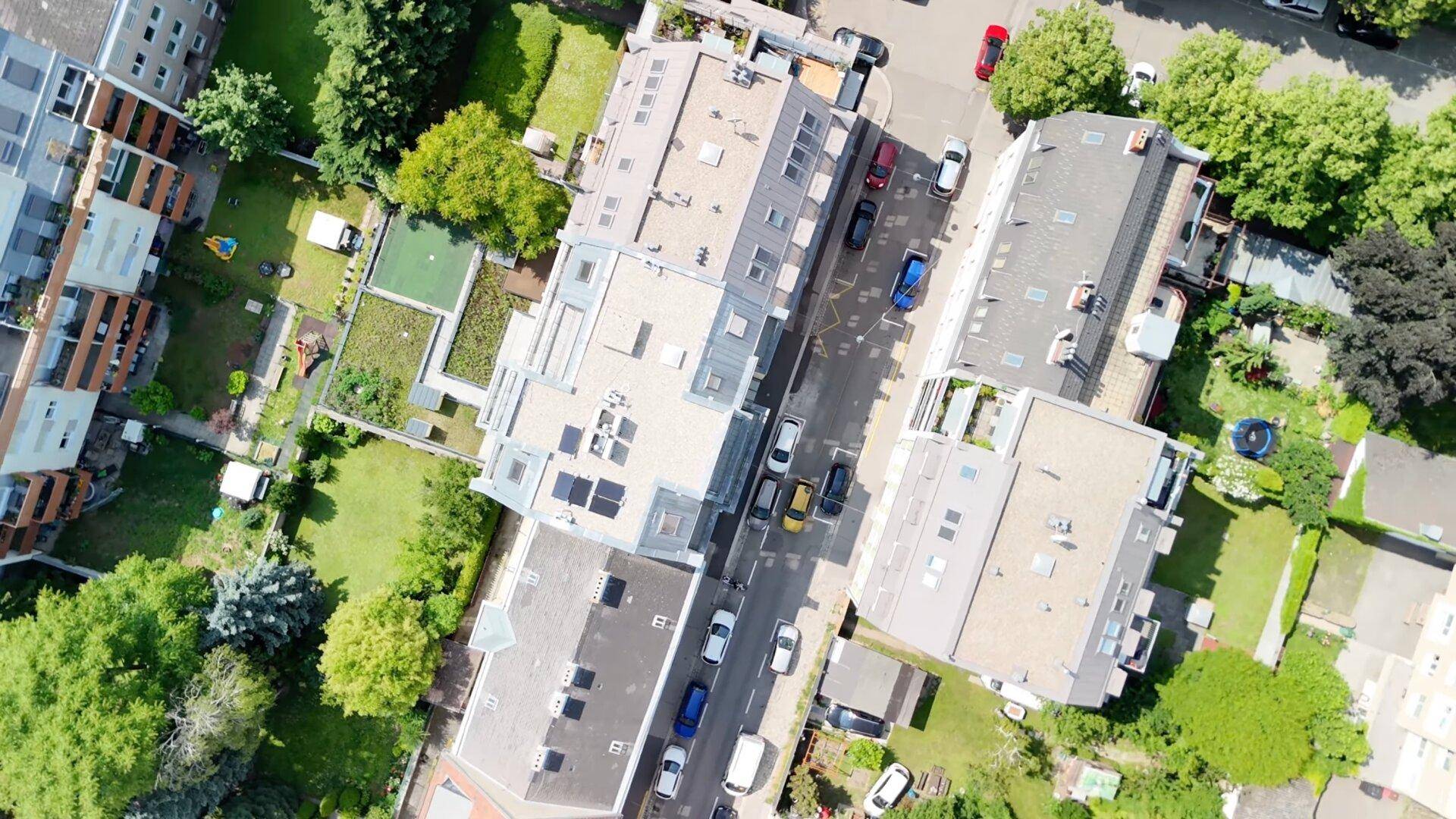 Weitläufige Luftaufnahme des Wohnkomplexes und der umliegenden Stadtlandschaft mit viel Grün.