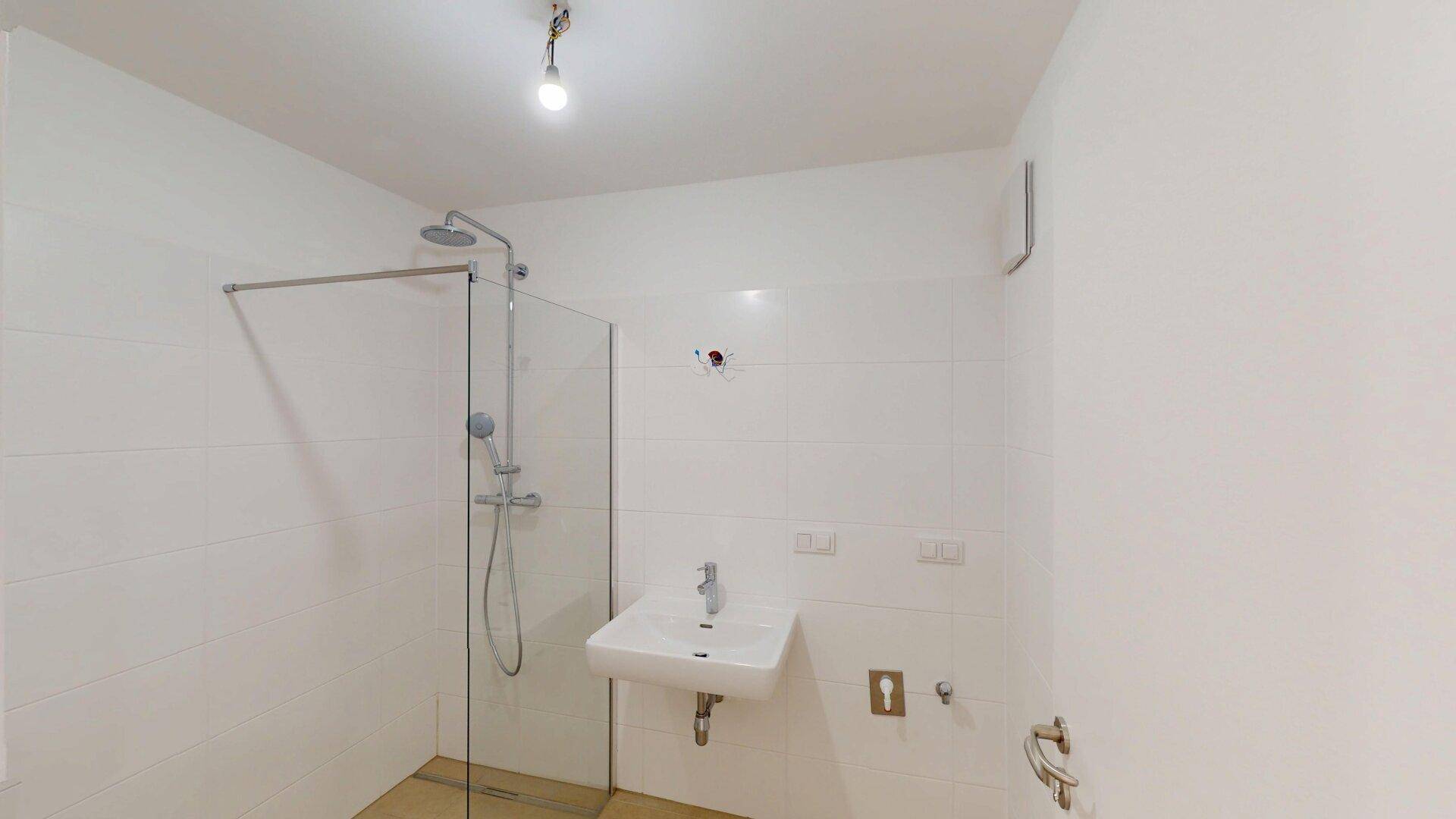 Modernes Badezimmer mit ebenerdiger Dusche, Fliesen und einem einzelnen Waschbecken.