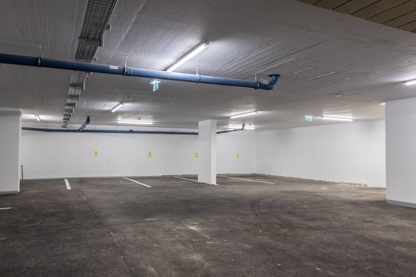 Geräumige Tiefgarage mit markierten Stellplätzen und guter Beleuchtung.