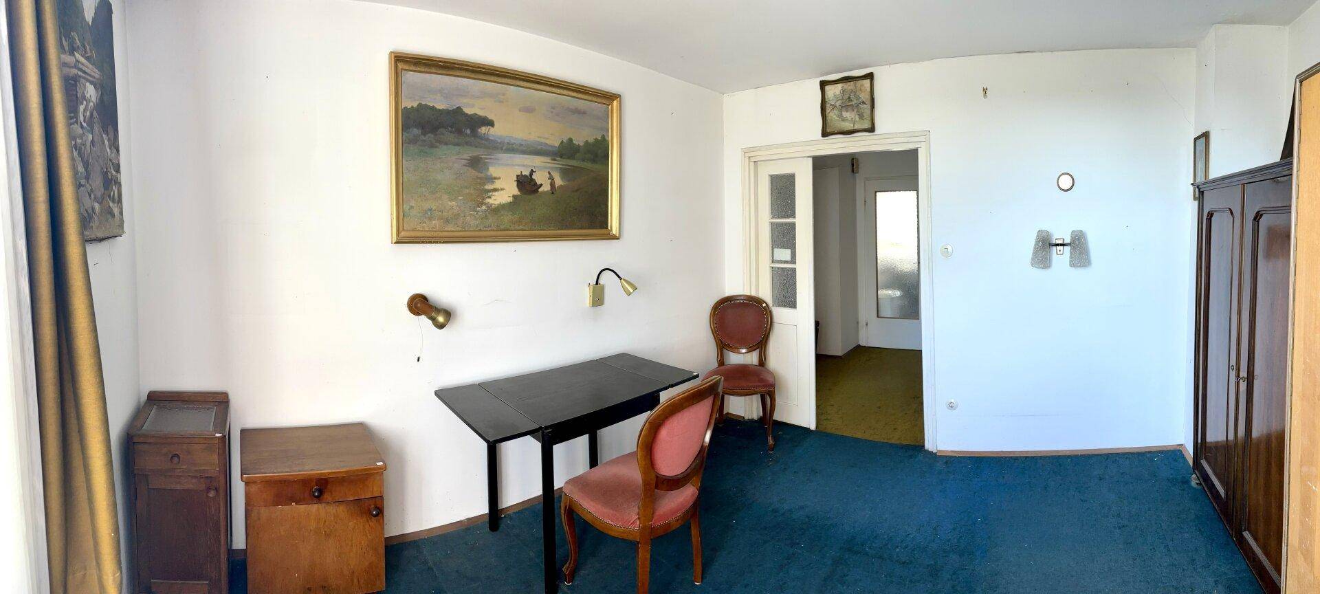 Helles Schlafzimmer mit Teppichboden, Schreibtisch und traditionellen Möbeln.