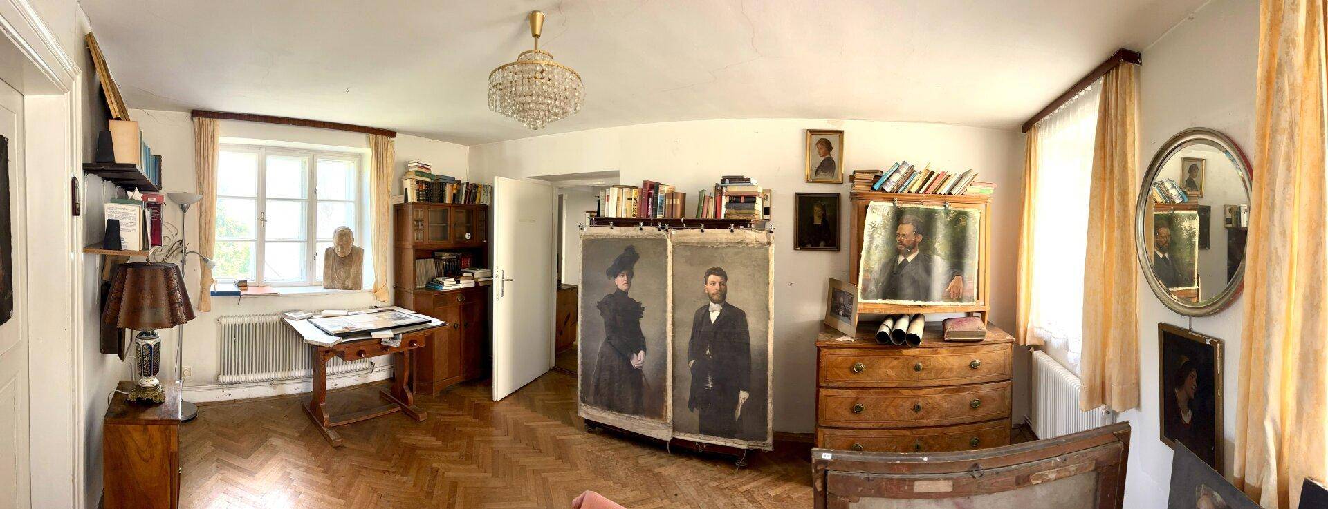 Großes Arbeitszimmer mit Parkettboden, Kronleuchter und zahlreichen Gemälden.