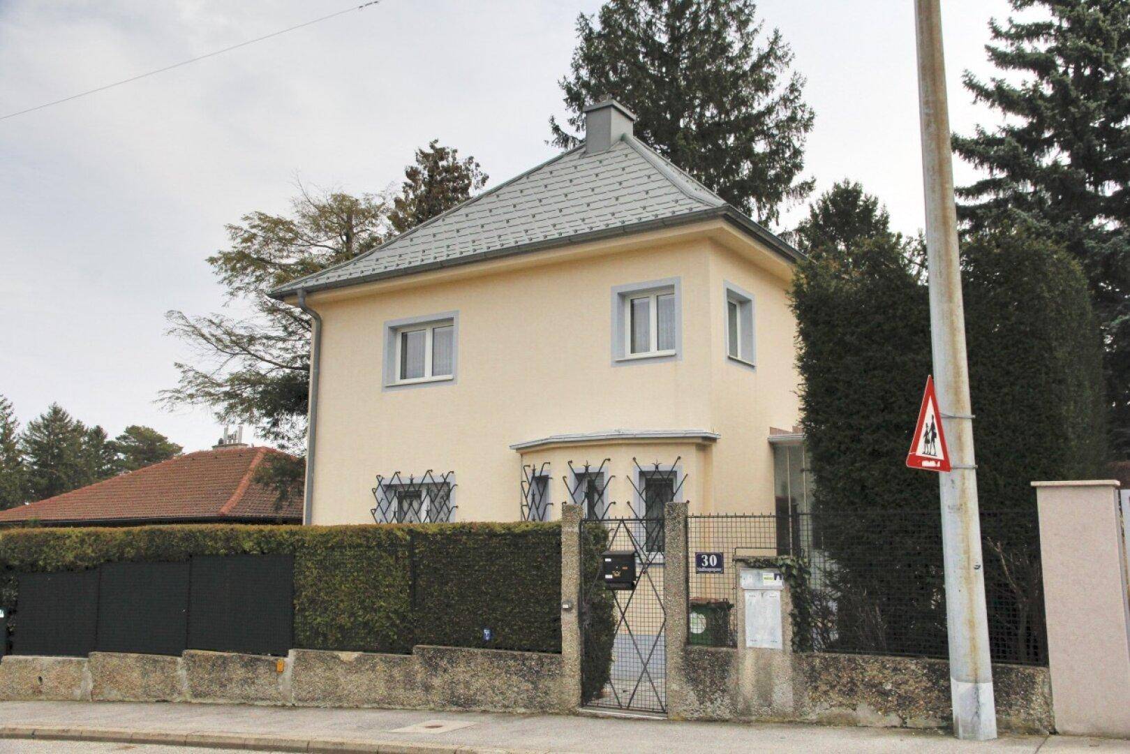 Charmantes Einfamilienhaus mit gepflegter Fassade, Vorgarten und Mansarddach.