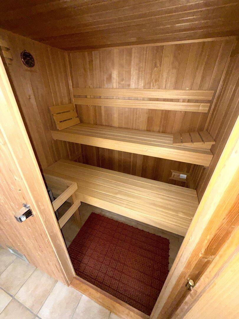 Gemütliche Holzsauna mit zwei Sitzebenen für Entspannung.
