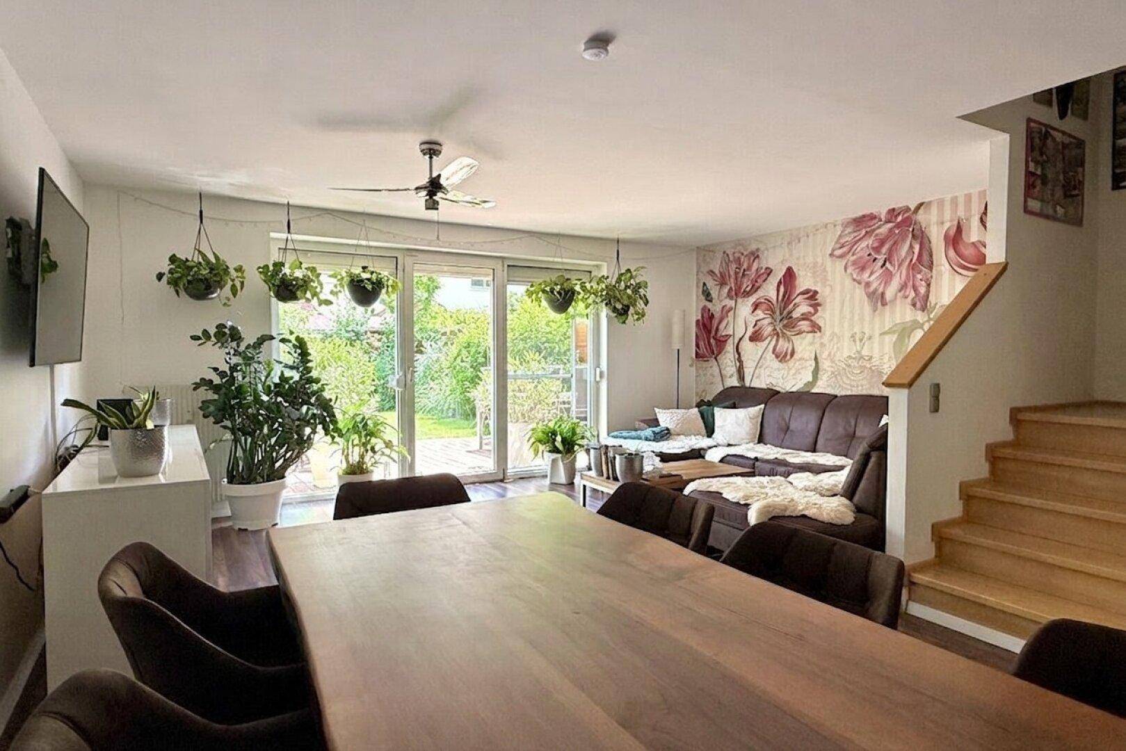 Geräumiger Wohn-Essbereich mit Esstisch, Sofa und Blick in den grünen Garten.