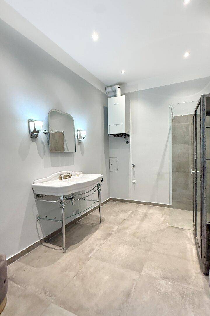 Geräumiges Badezimmer mit klassischem Waschtisch, moderner Dusche und Wandheizung.