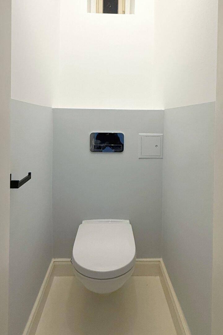 Kleines, helles WC mit wandhängender Toilette und minimalistischem Design.