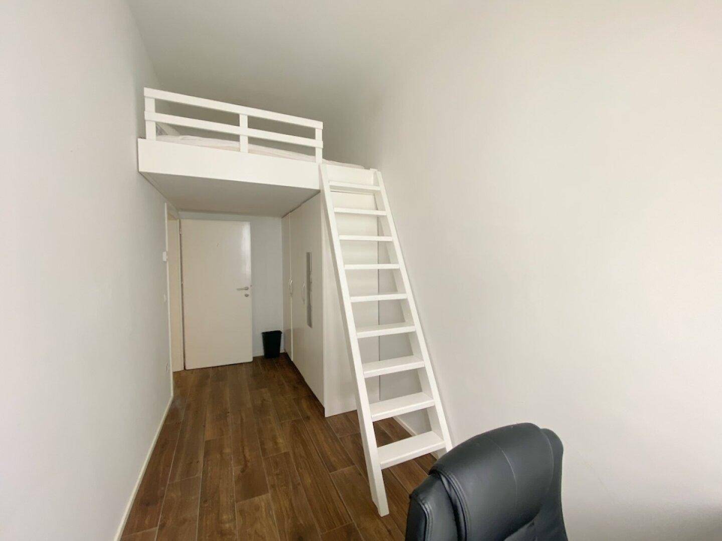 Zimmer mit Hochbett und Leiter, bietet eine effiziente Raumnutzung für Wohnen und Schlafen, auf Holzfußboden.