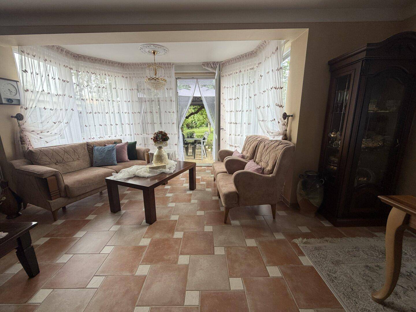 Gemütlicher Wohnbereich mit bequemen Sofas, Couchtisch und direktem Zugang zum grünen Außenbereich.