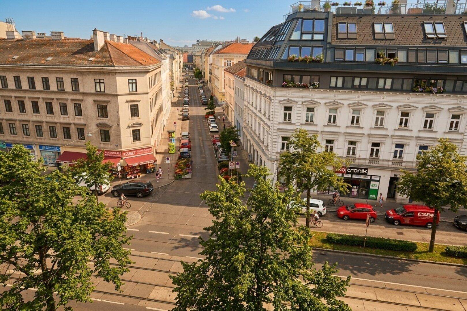 Panoramablick auf eine belebte Stadtstraße mit historischen Gebäuden und Geschäften.
