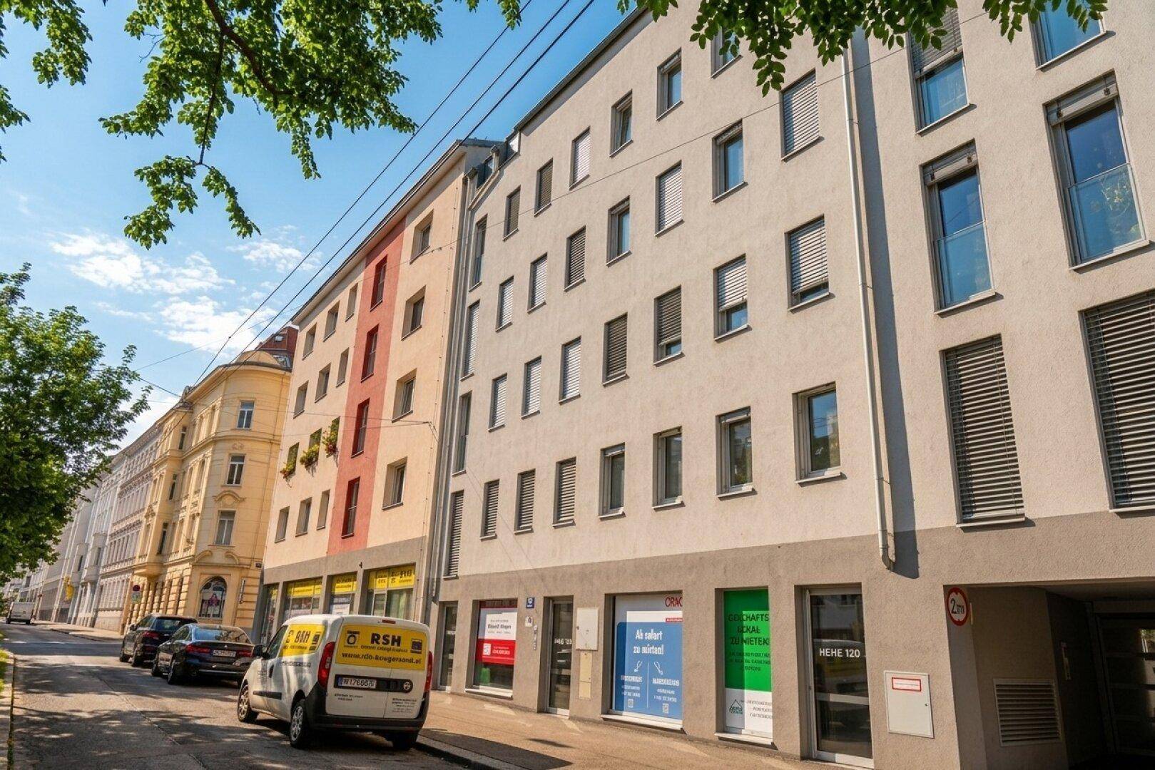 Moderne Wohngebäude an einer Stadtstraße mit Geschäften im Erdgeschoss.