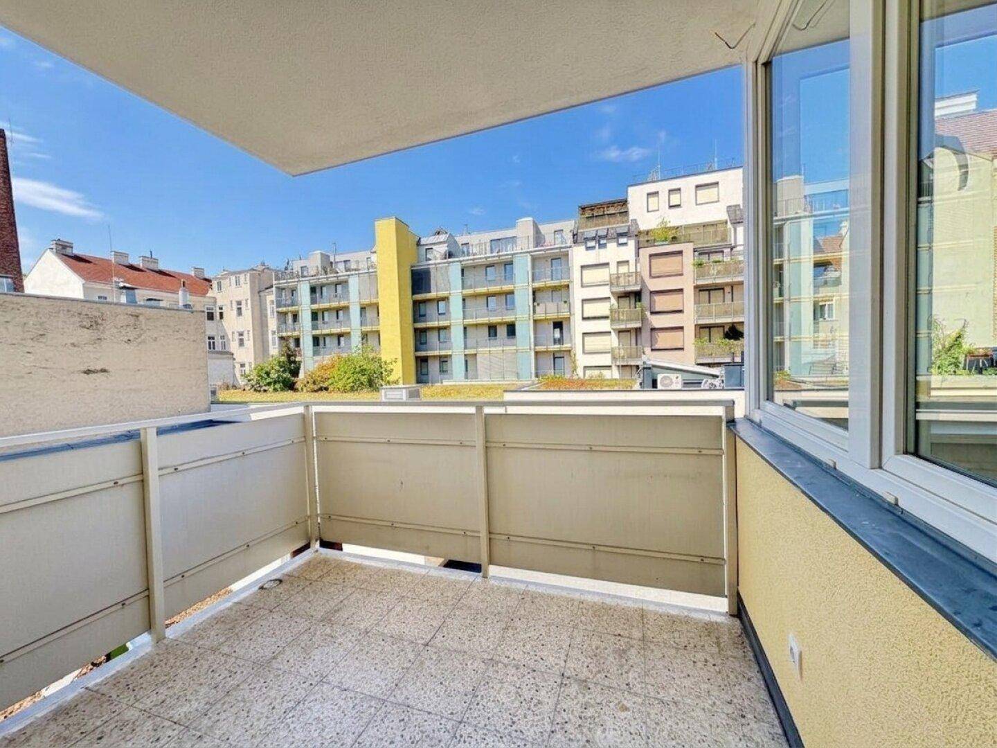 Balkon mit Fliesenboden und weitem Blick auf die umliegende Stadtbebauung.