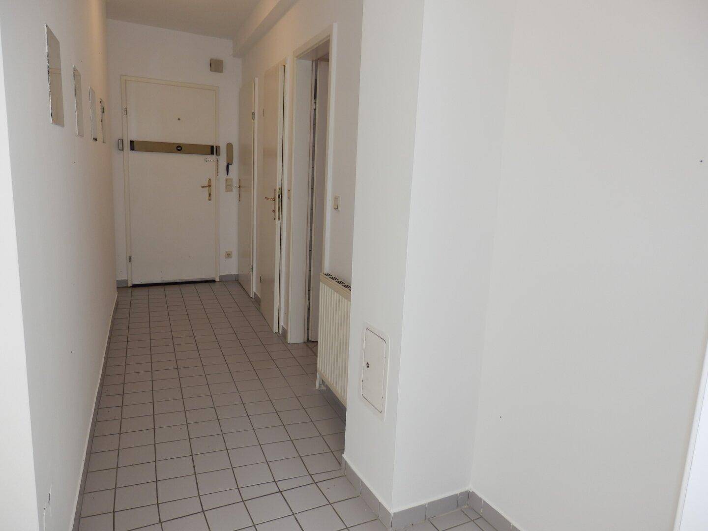 Geräumiger Eingangsbereich mit Fliesenboden und mehreren Türen, bietet Zugang zu allen Zimmern.