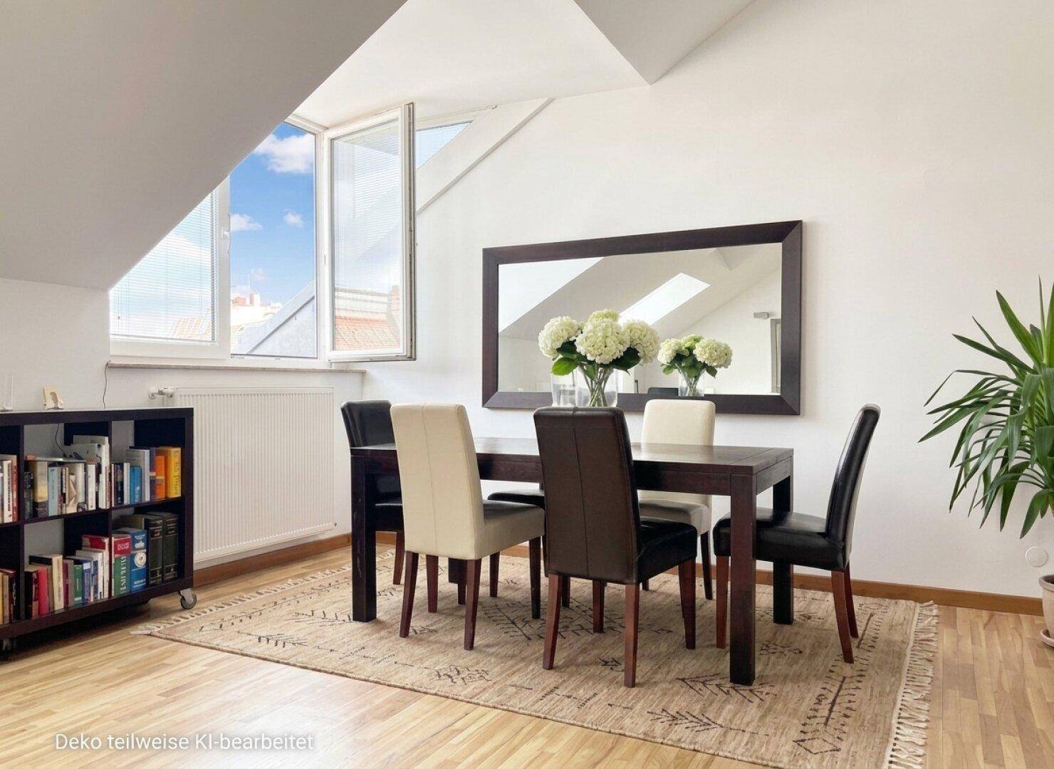 Eleganter Essbereich in Dachgeschosswohnung mit großem Holztisch, Spiegel und Blick nach draußen.