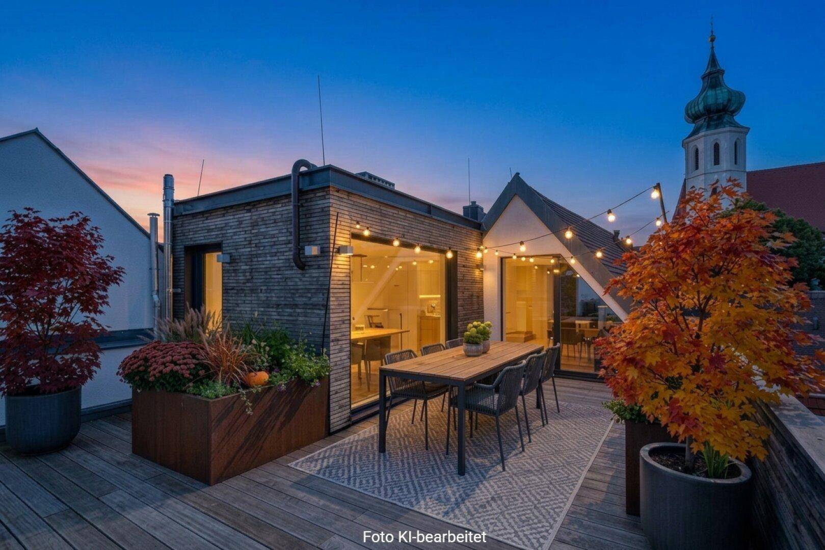 Stilvolle Dachterrasse mit Esstisch, Pflanzen und stimmungsvoller Beleuchtung bei Sonnenuntergang.