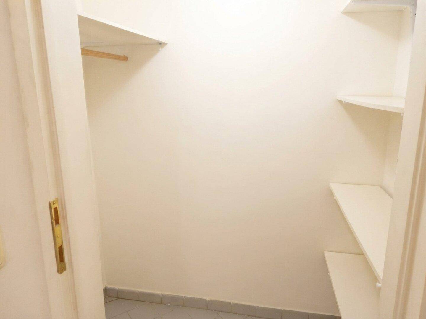 Kleiner Abstellraum mit Regalen und Kleiderstange, ideal für zusätzlichen Stauraum.