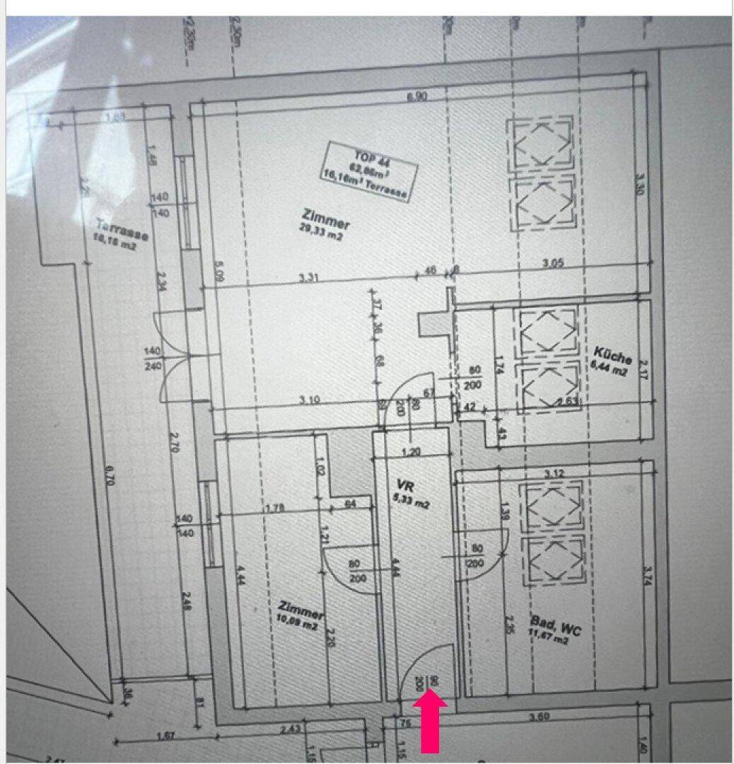 Grundriss einer Wohnung mit zwei Zimmern, Bad, Küche und großer Terrasse.