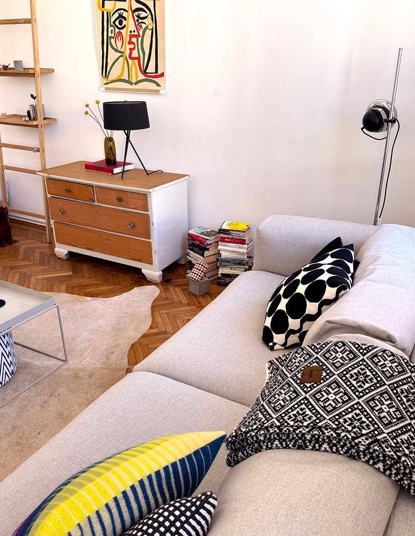 Gemütliches Sofa mit bunten Kissen und moderner Kunst an der Wand im Wohnbereich.