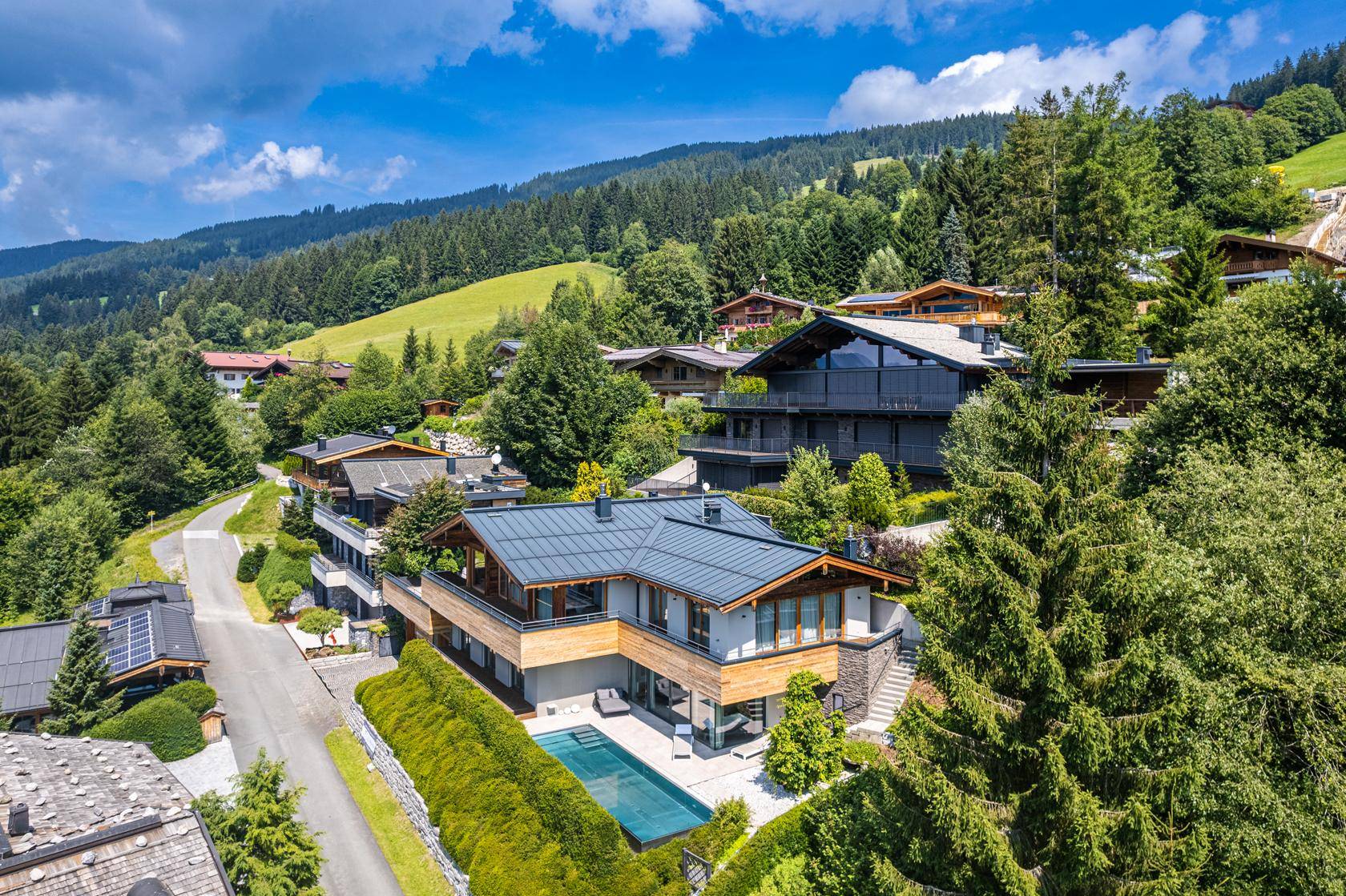 Luxuriöse Villa in alpiner Umgebung mit Pool und Panoramablick auf die Berge.