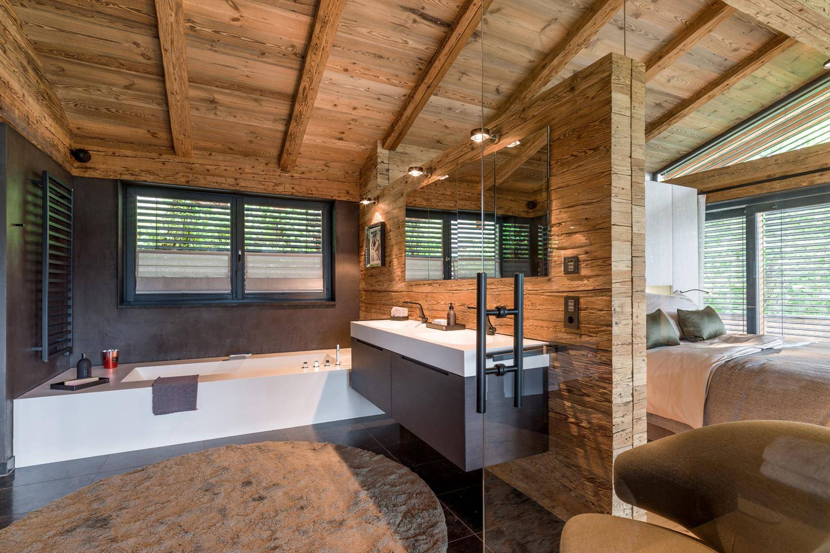 Modernes Badezimmer mit Badewanne, Doppelwaschbecken und Holzbalkendecke.