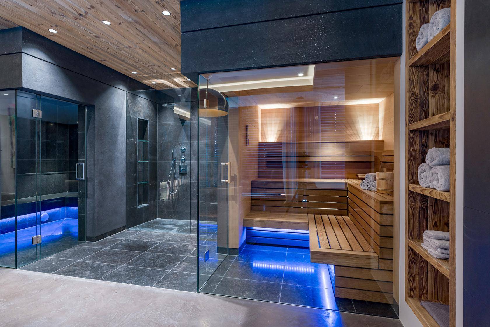 Moderner Wellnessbereich mit Sauna, Regendusche und stilvoller Beleuchtung.