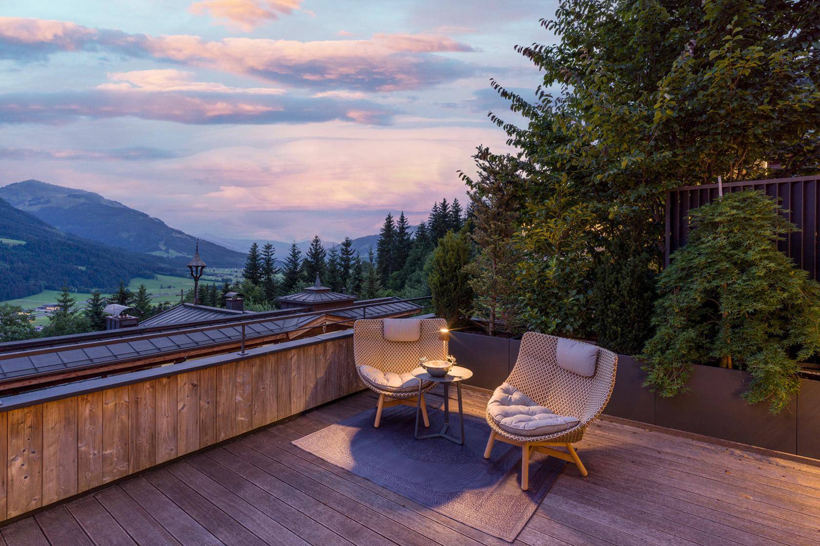 Gemütliche Terrasse am Abend mit Sitzgelegenheiten und malerischem Bergblick.