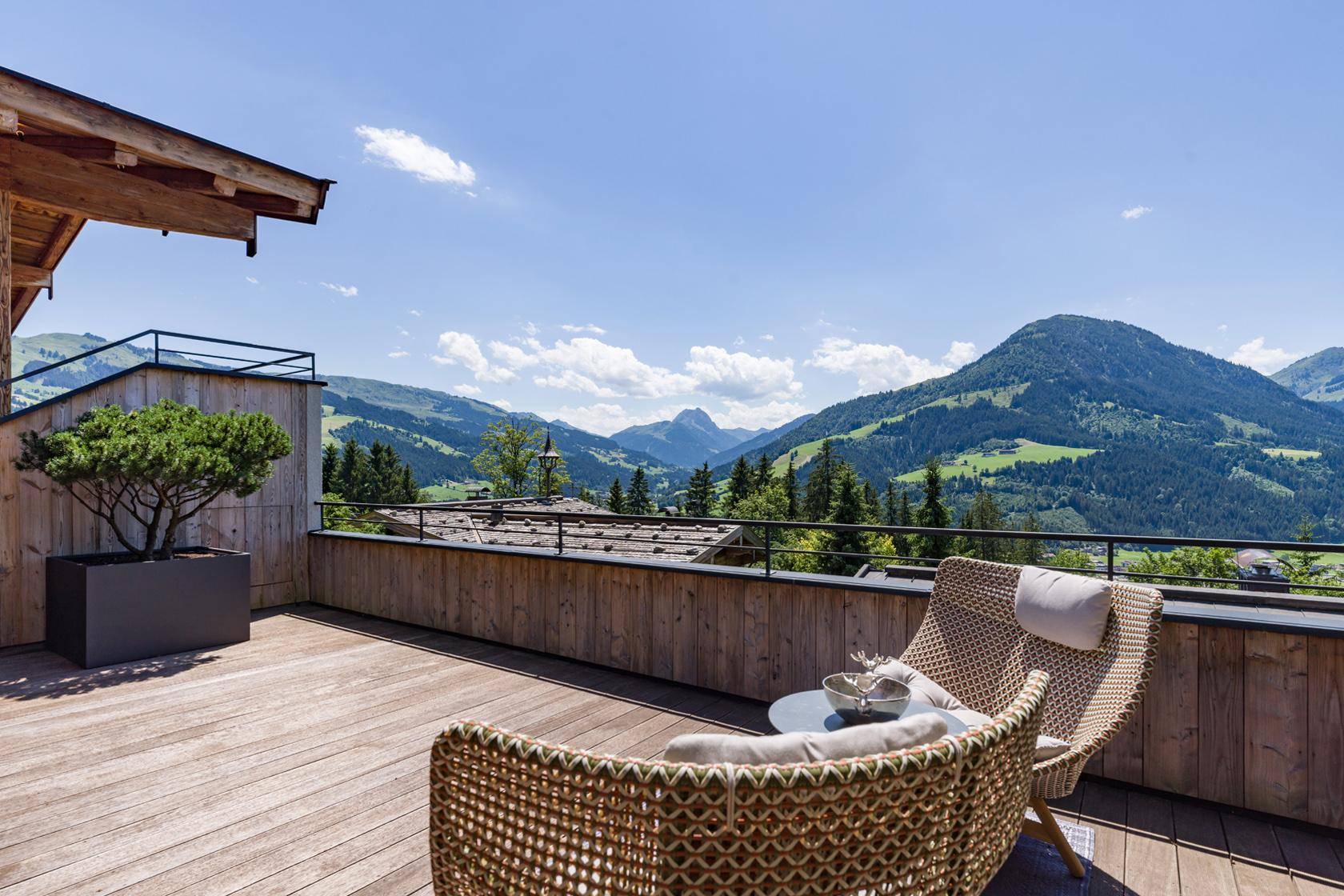 Sonniger Balkon mit bequemen Sitzgelegenheiten und atemberaubendem Bergblick.