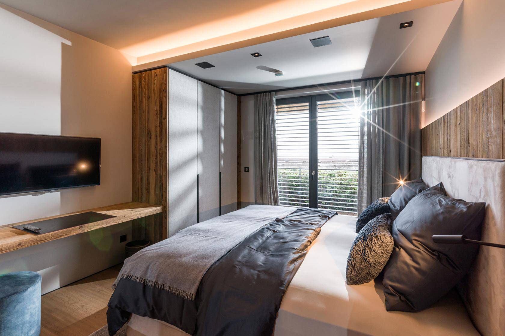 Komfortables Schlafzimmer mit großem Bett, Einbauschränken und viel natürlichem Licht.
