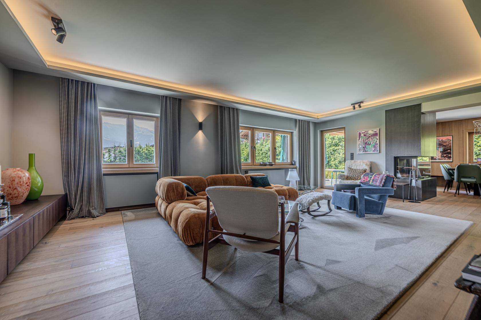 Geräumiges Wohnzimmer mit Parkettboden, bequemen Sofas und Blick ins Grüne.