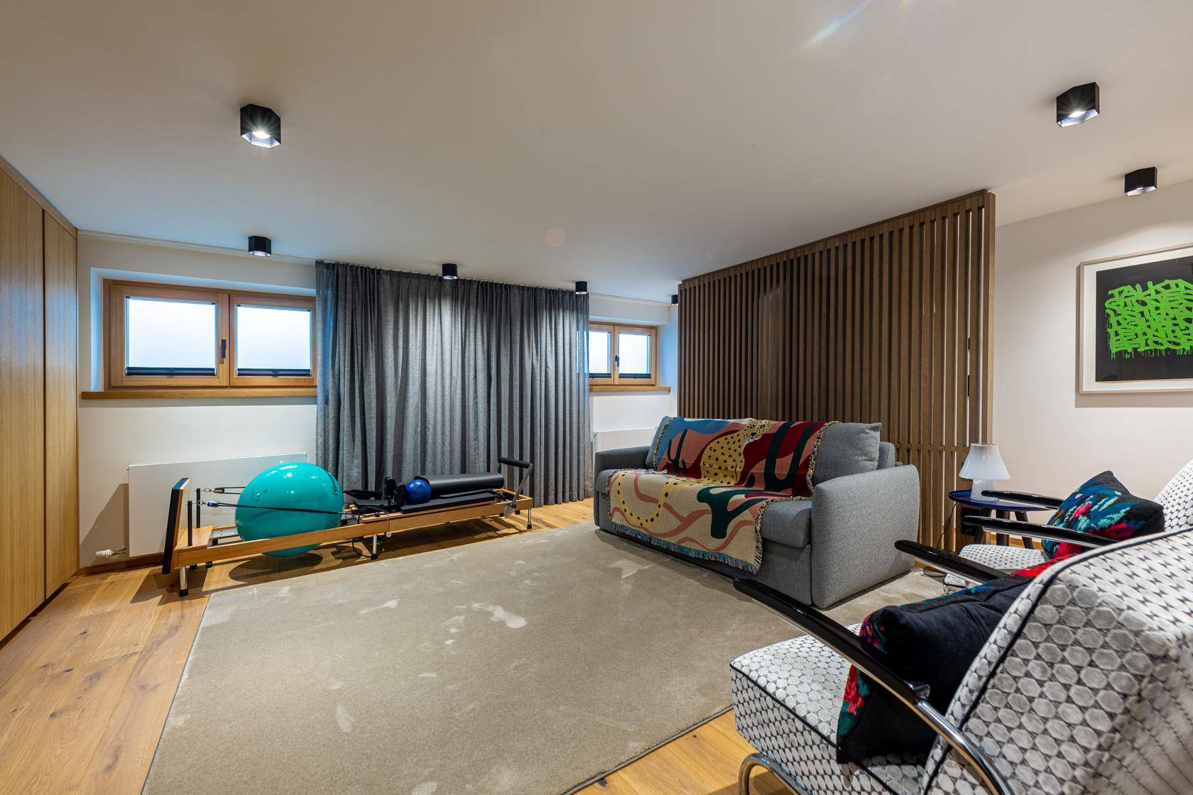 Vielseitiger Raum mit Fitnessgeräten, Sofa und Holzfußboden.