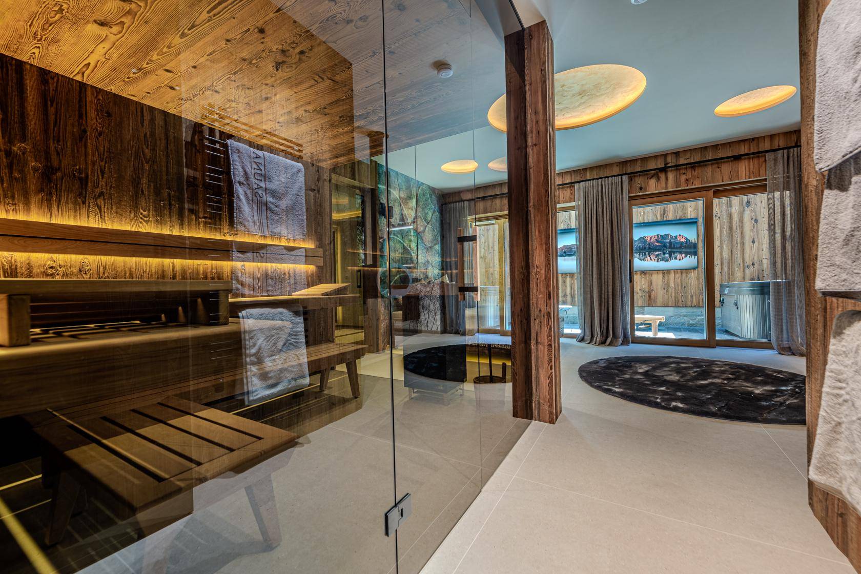 Exklusiver Wellnessbereich mit moderner Sauna, Holzakzenten und großen Fenstern für viel Tageslicht.