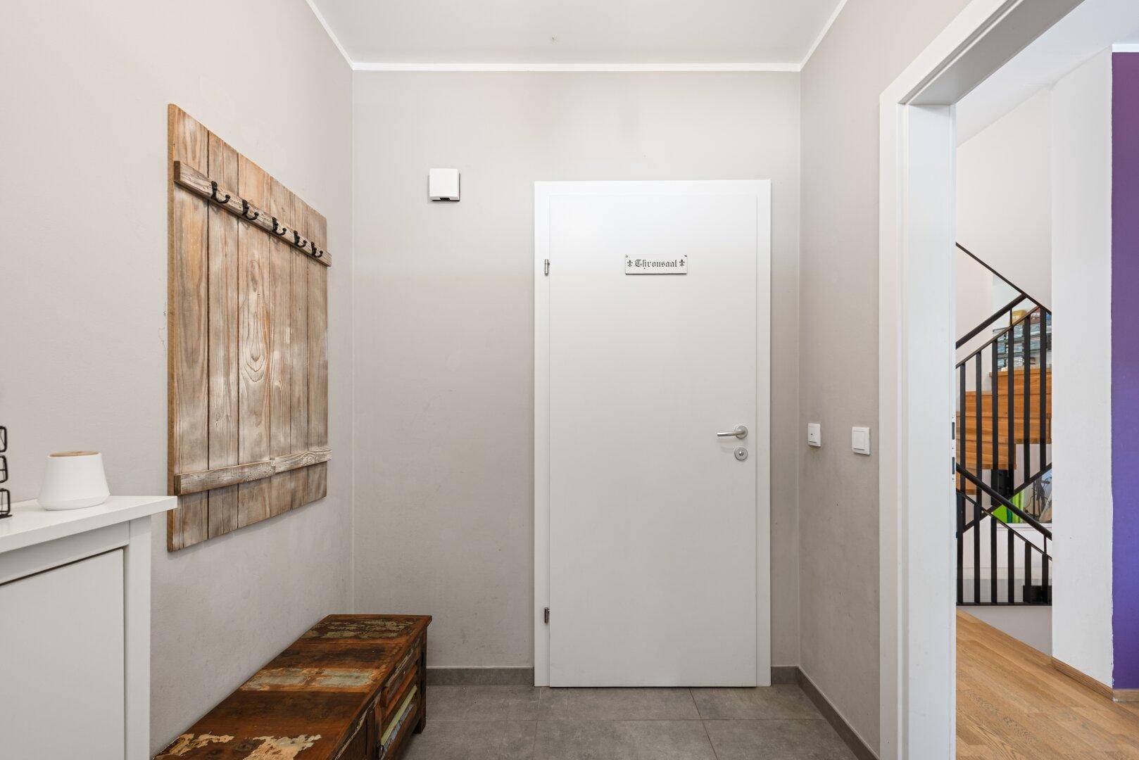 Heller Eingangsbereich mit Fliesenboden, Garderobe und Zugang zu den Wohnräumen.