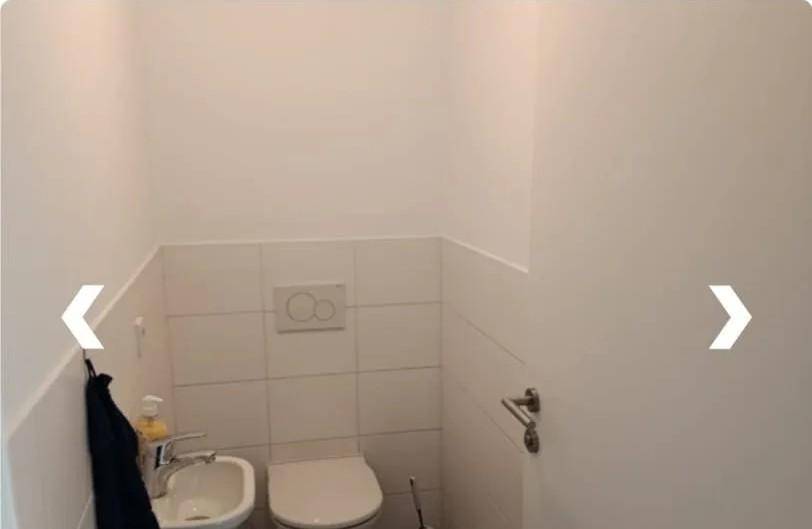 Kleines Gäste-WC mit wandhängender Toilette, Bidet und weißen Wandfliesen, praktisch und platzsparend.