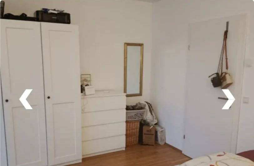 Schlafzimmerbereich mit weißem Kleiderschrank, Kommode und einem Spiegel an der Wand für zusätzlichen Komfort.