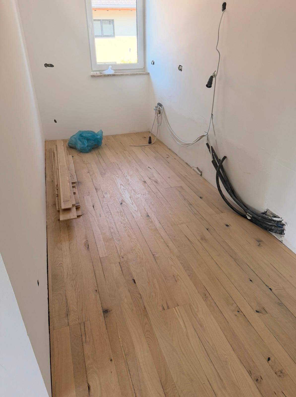 Heller Raum im Bau mit neuem Holzboden und Fenster.