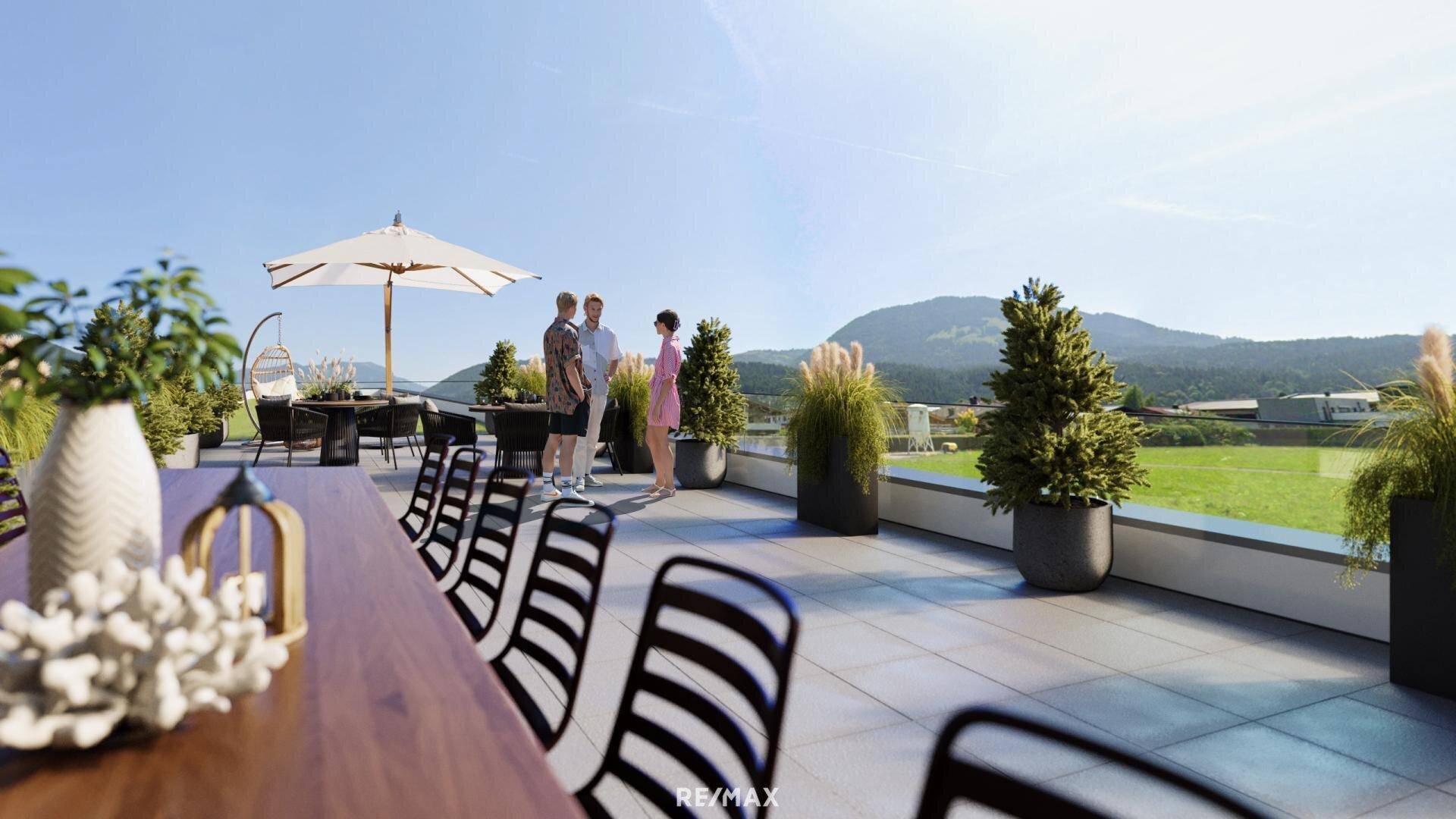 Geräumige Dachterrasse mit Sitzgelegenheiten, Pflanzen und weitem Blick auf die umliegende Berglandschaft.