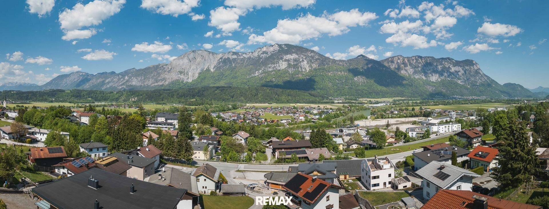 Weitläufiger Panoramablick über eine ländliche Siedlung mit majestätischer Bergkulisse im Hintergrund.