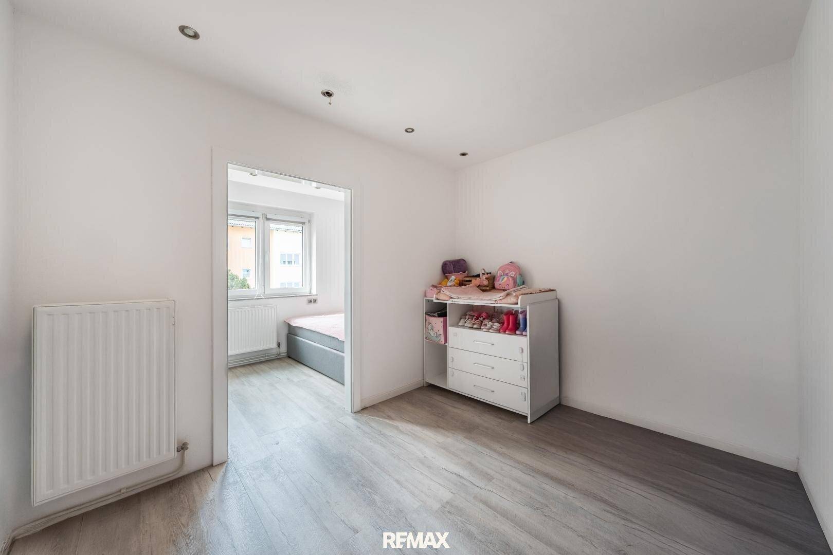 Kinderzimmer mit Wickelkommode und Zugang zu einem weiteren Raum.