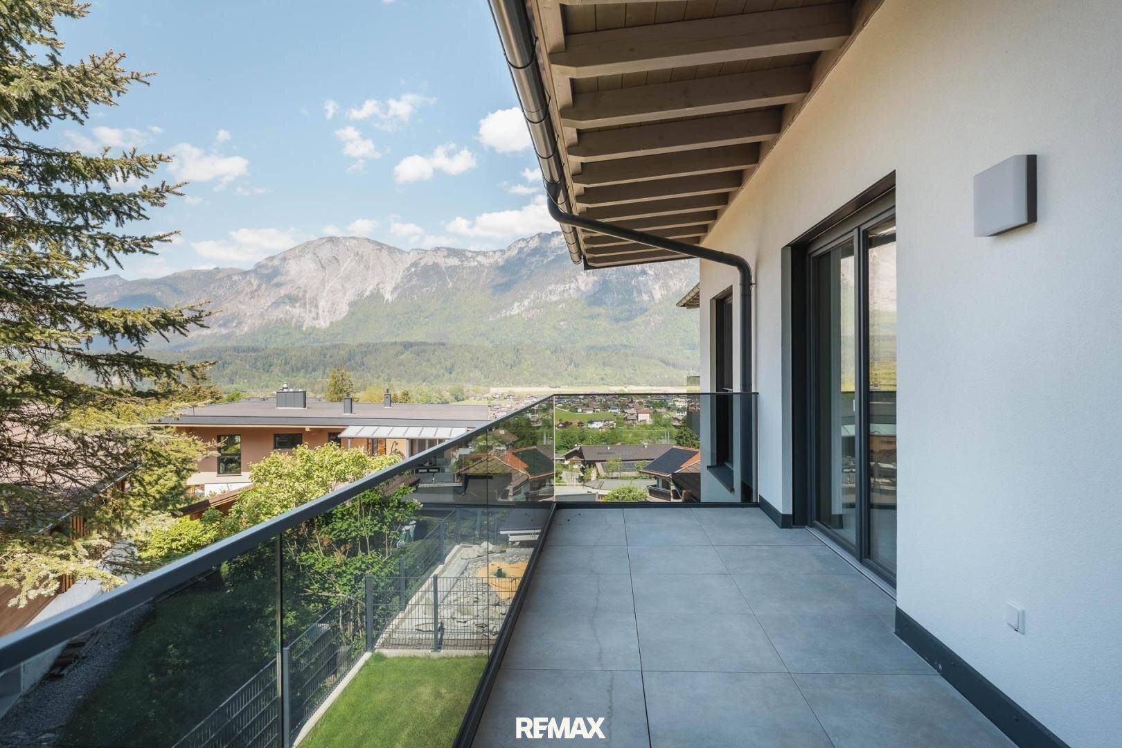 Geräumiger Balkon mit Glasgeländer und atemberaubendem Panoramablick auf die Berge.