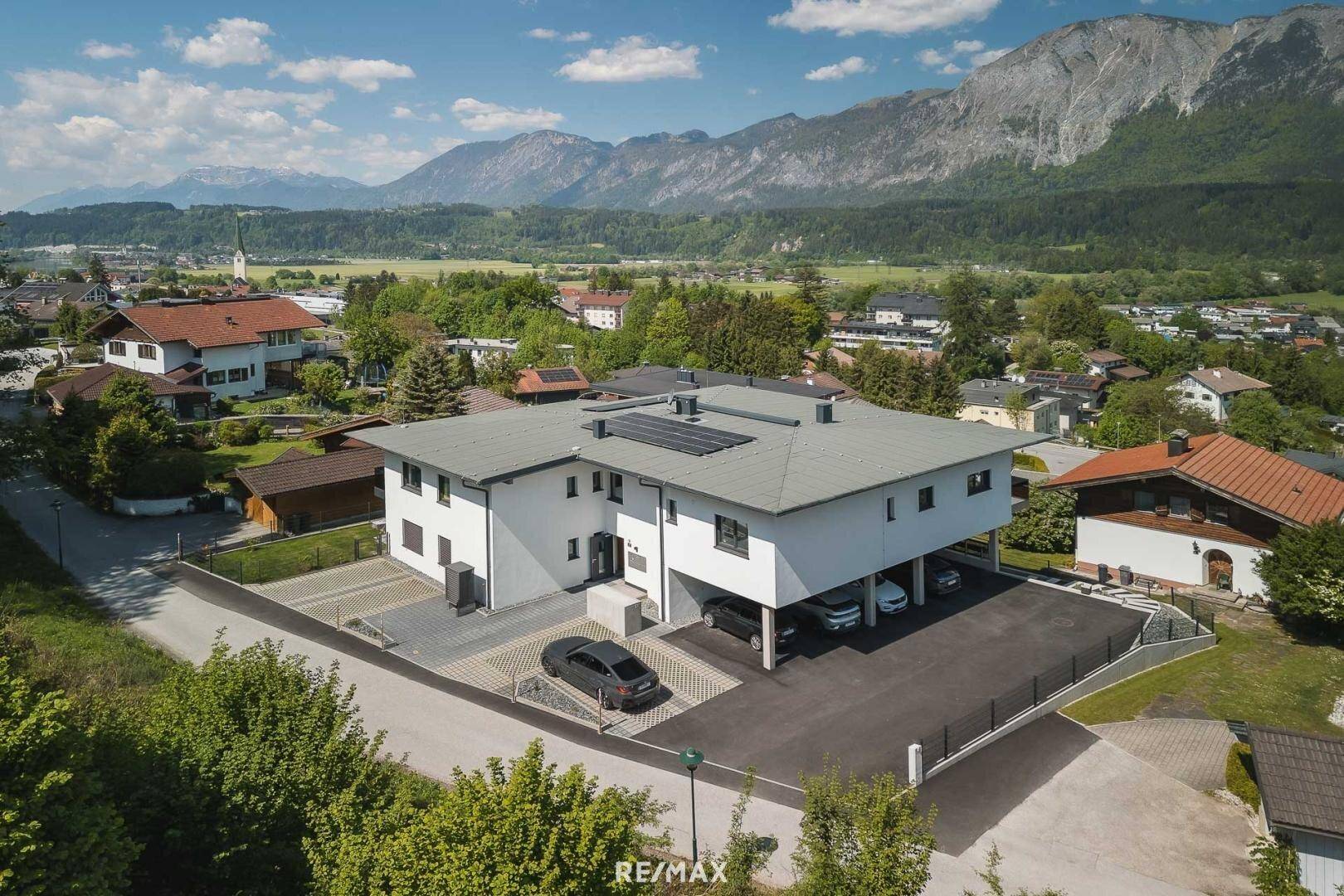 Luftaufnahme der modernen Wohnanlage mit Photovoltaikanlage und Bergblick in der Nachbarschaft.