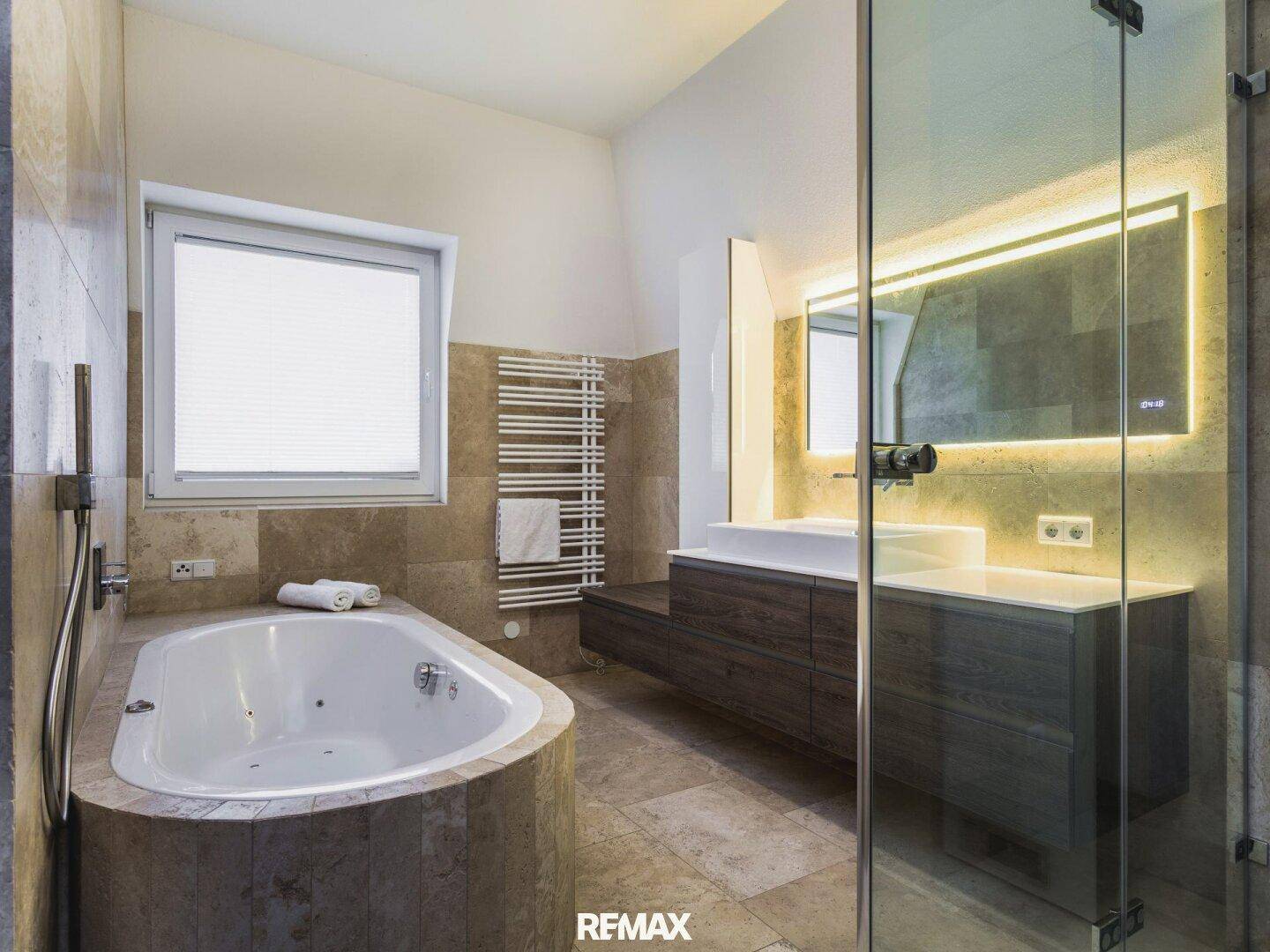 Modernes Badezimmer mit Eckbadewanne, separater Dusche, Doppelwaschbecken und Fenster.