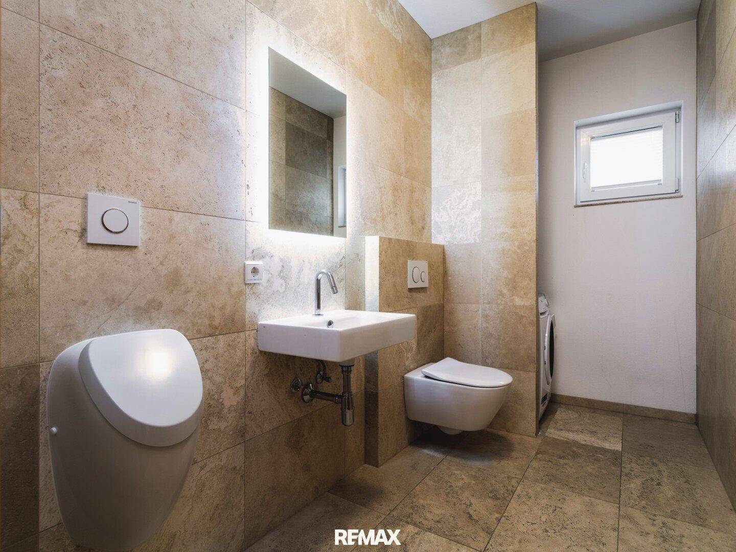 Modernes Badezimmer mit Urinal, wandhängendem WC, Einzelwaschbecken und Fenster.