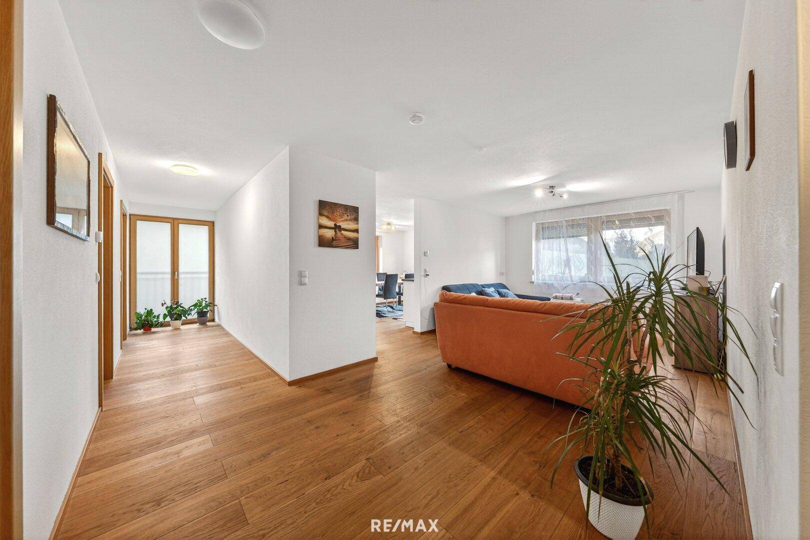 Heller Flur mit Holzboden und Zugang zu weiteren Räumen, modern eingerichtet.