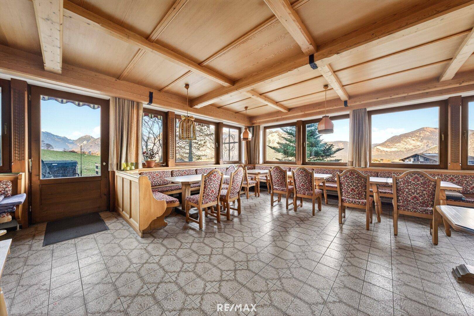 Großer Essbereich im traditionellen Stil mit Holztischen, Bänken und Fliesenboden.