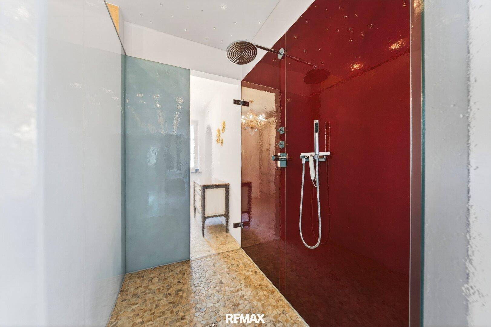 Moderne Duschkabine mit roten Glaswänden, Regendusche und stilvollem Design.