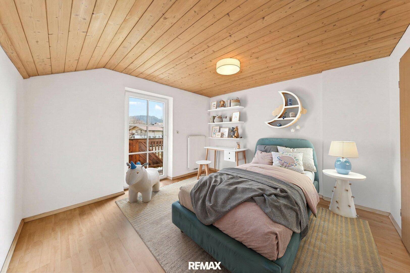 Kinderzimmer mit Holzbalkendecke, Zugang zum Balkon und Blick auf die umliegende Landschaft.