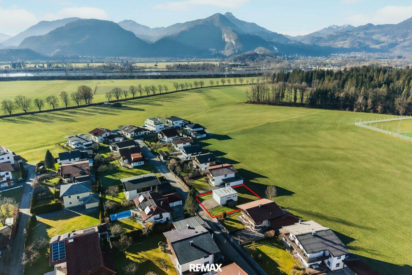 Panoramablick aus der Vogelperspektive auf das Grundstück, eingebettet in eine weite Landschaft mit Bergen.