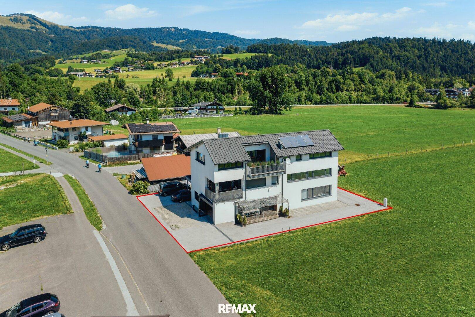 Luftaufnahme des Hauses in idyllischer ländlicher Lage mit umliegenden Wiesen und Bergen.