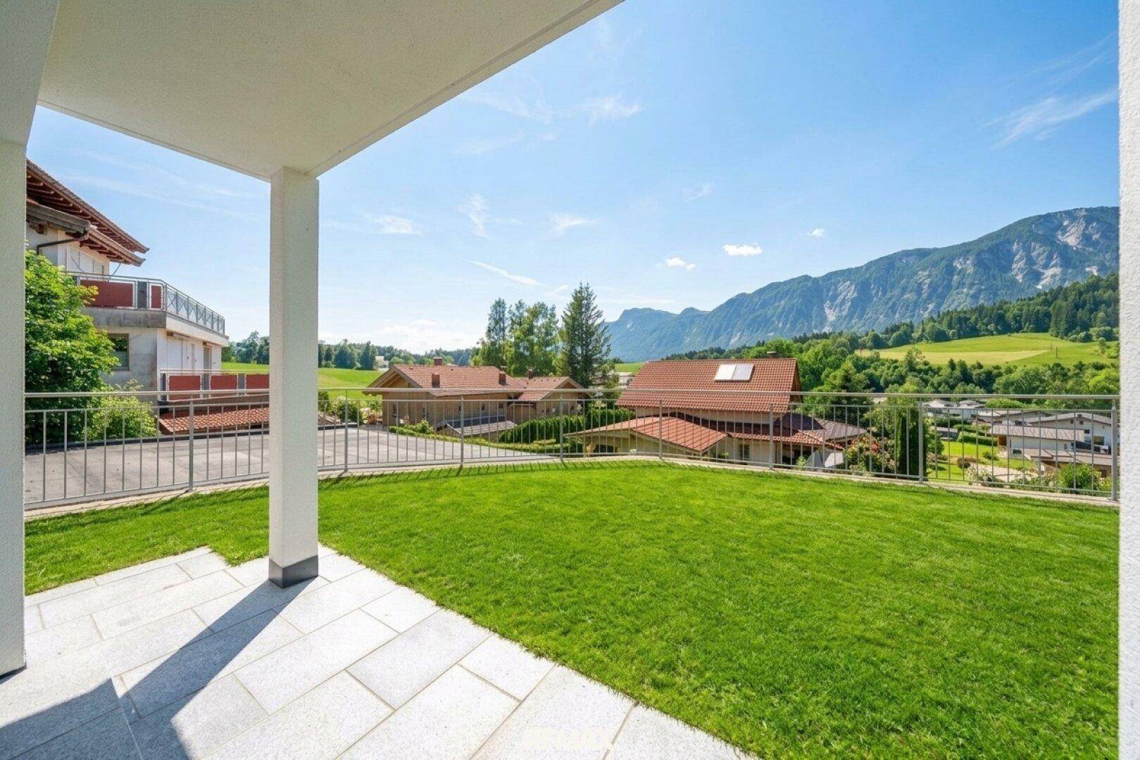 Große, sonnige Terrasse mit Rasenfläche und weitem Blick auf die Berge.